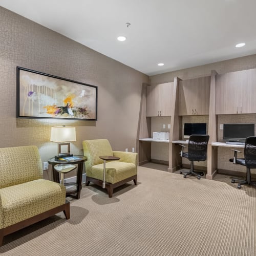 Business workstations with printer and cushioned desk chairs nearby of Marq at Crabtree in Raleigh, North Carolina