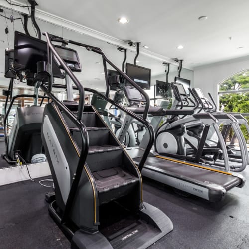 Stair climber, treadmills, and elliptical machines facing mirrors at Marquis Midtown District in Atlanta, Georgia