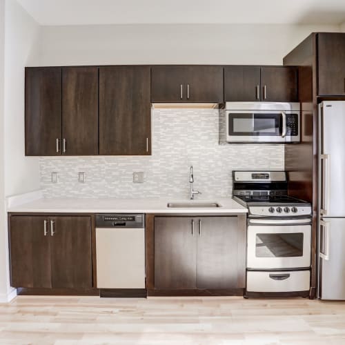 Clean kitchen with stainless steel appliances and dark wood style cabinets at 1350 Florida in Washington, District of Columbia