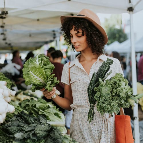 Trying to decide which produce she should take home from the farmers market near Bristol House in Washington, District of Columbia