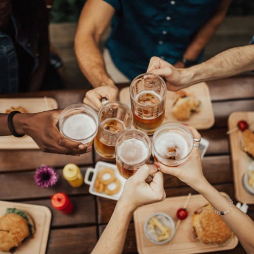 Saying cheers with a group of friends while having drinks and dinner near Dorchester West in Washington, District of Columbia