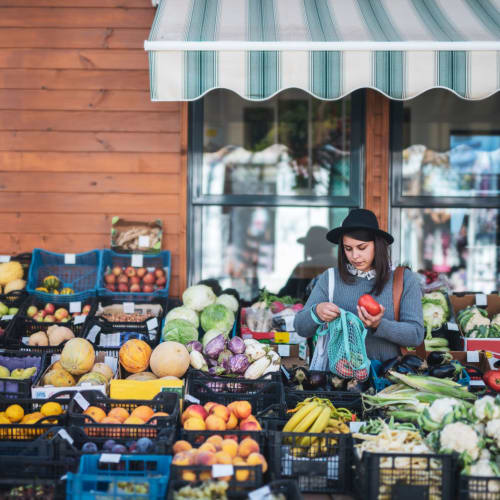 Woman picking out some fresh produce at a market near Madrona Apartments in Washington, District of Columbia