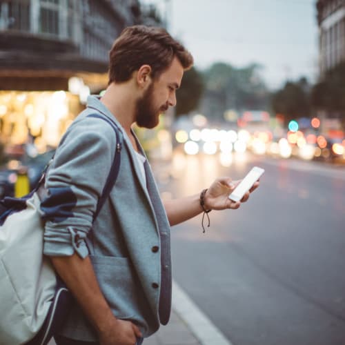 Resident checking his phone while he walks home from work near Winston House in Washington, District of Columbia