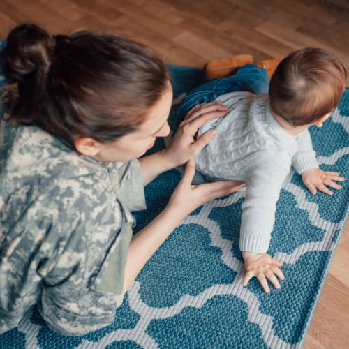 woman with her infant on the floor at Stone Park in Lemoore, California