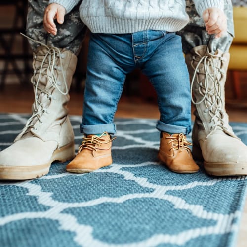 a resident and their child showing off their boots at Stanley Court in Portsmouth, Virginia