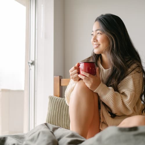 a woman smiling enjoying her morning coffee at North Severn Village in Annapolis, Maryland