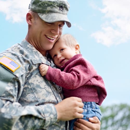 a resident holding his infant at Santa Cruz in Point Mugu, California