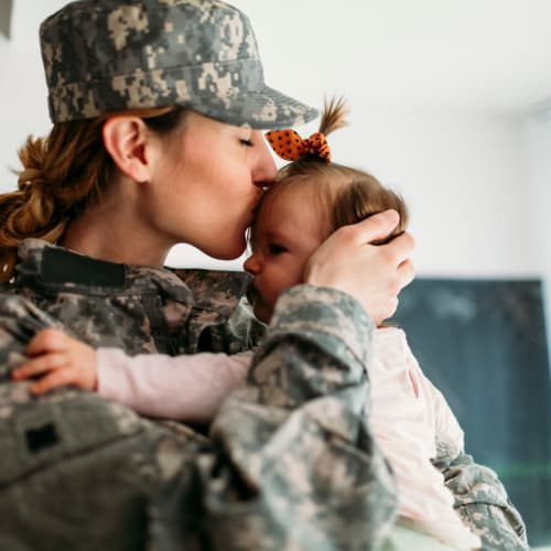 a resident kissing her daughter at San Miguel in Point Mugu, California