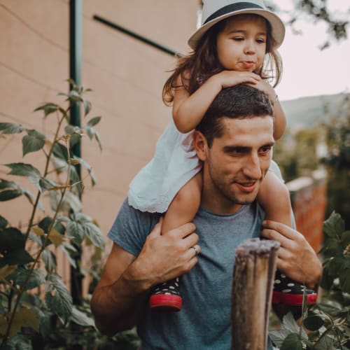 a resident with their daughter on their shoulders at San Miguel in Point Mugu, California