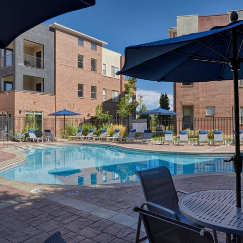 Refreshing swimming pool surrounded by lounge chairs on a nice sunny day at Marq Inverness in Englewood, Colorado