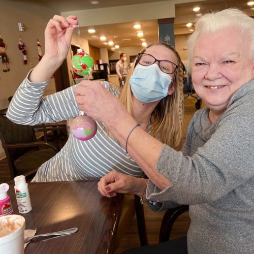 A masked team member with a resident at The Oxford Grand Assisted Living & Memory Care in McKinney, Texas