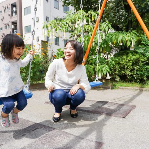 a mother playing with her son on the swing set at Home Terrace in San Diego, California