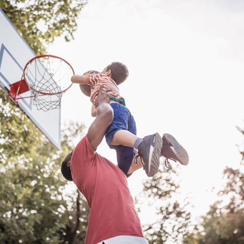 a father playing basketball with his son at Miramar Townhomes in San Diego, California