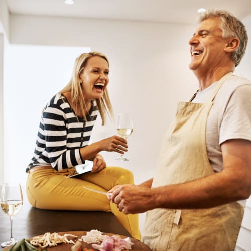 two residents laughing in the kitchen at Sea Breeze Village in Seal Beach, California