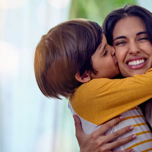 a mother getting  kiss from their child at Sunflower Terrace in Twentynine Palms, California