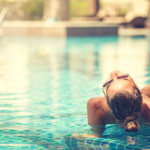 a resident lounging in the pool at Howard Gilmore Terrace in La Mesa, California