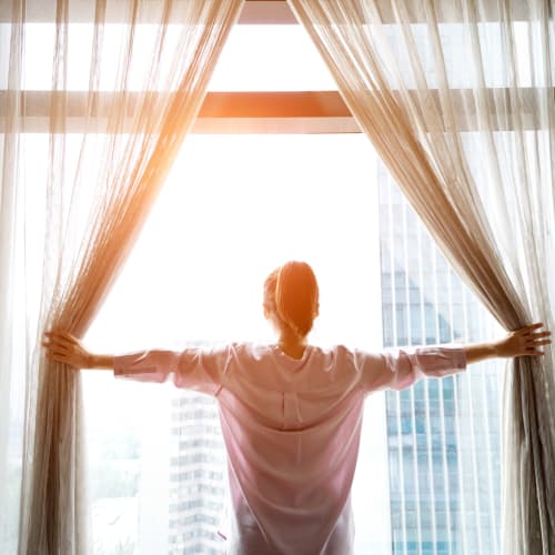 a resident opening curtains at Port Lyautey in Virginia Beach, Virginia