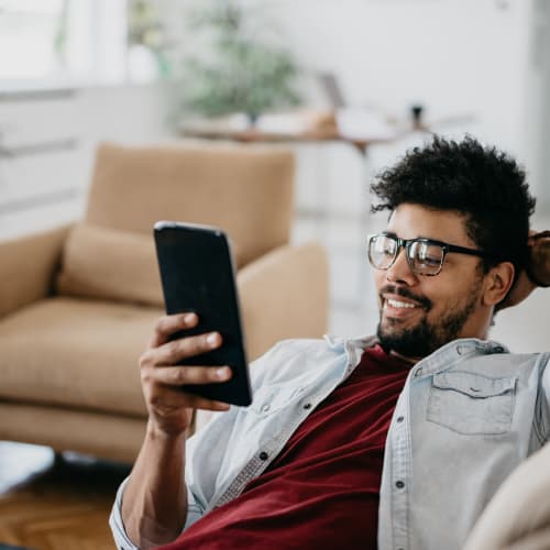 a resident smiling at his phone at Mira Mesa Ridge in San Diego, California