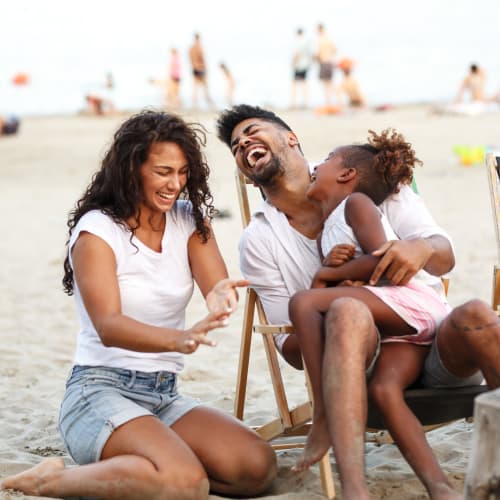 a resident family smiling at a sandy park at The Village at New Gosport in Portsmouth, Virginia