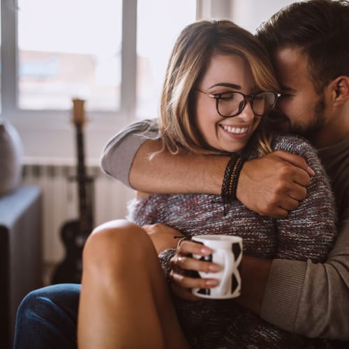 a resident couple cozied up on the couch with coffee at Davis Hill in Joint Base Lewis McChord, Washington