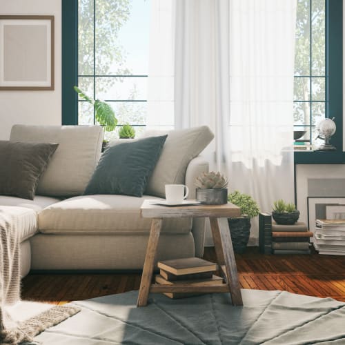 Well-furnished living space with large bay windows in a model apartment at Farmstead at Lia Lane in Santa Rosa, California