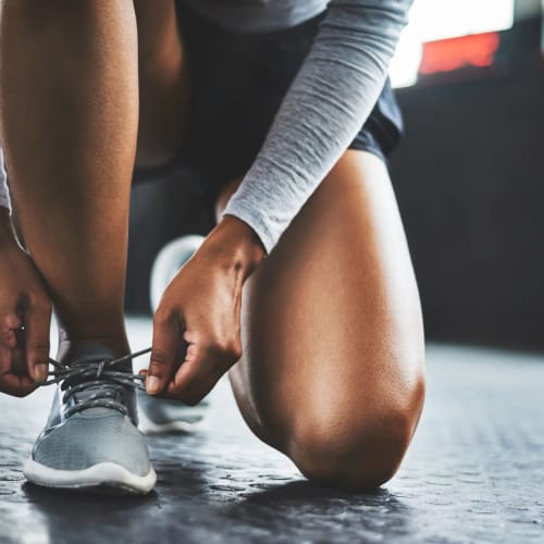 Resident tying their shoes and getting ready to use the on-site fitness facility at Parc at Maplewood Station in Maplewood, New Jersey