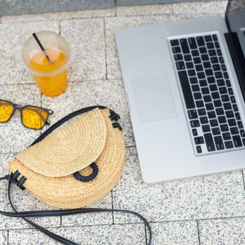 Laptop and other items on a bench outside at Catalina Crest Apartment Homes in Livermore, California