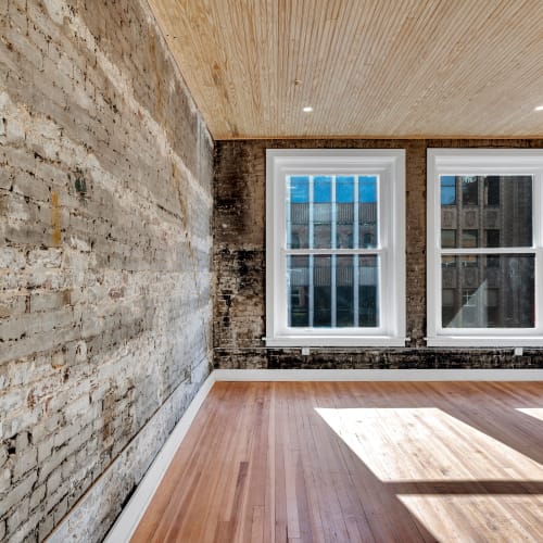 A loft living room with rustic brick wall at Theatre Lofts in Birmingham, Alabama