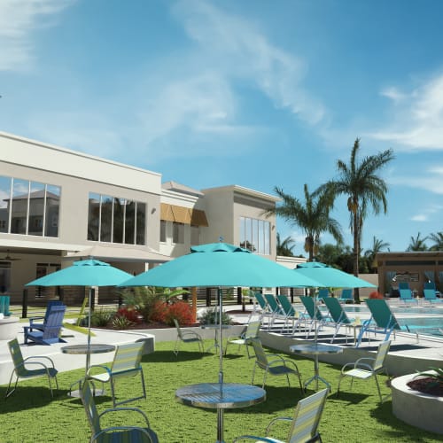 Seating and tables with umbrellas around the community pool at Mallory Square at Lake Nona in Orlando, Florida