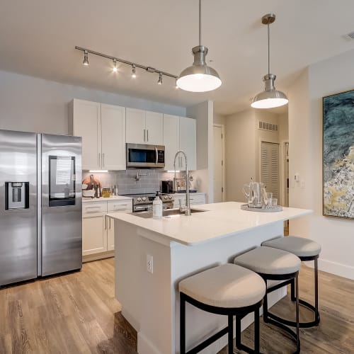 Stainless steel appliances and modern lighting in an apartment kitchen at Mallory Square at Lake Nona in Orlando, Florida
