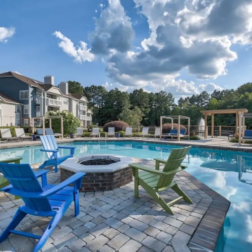 A firepit with seating next to the community swimming pool at Copper Mill Apartments in Richmond, Virginia