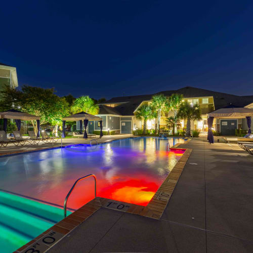 Swimming pool with fun lights at night at Spring Water Apartments in Virginia Beach, Virginia