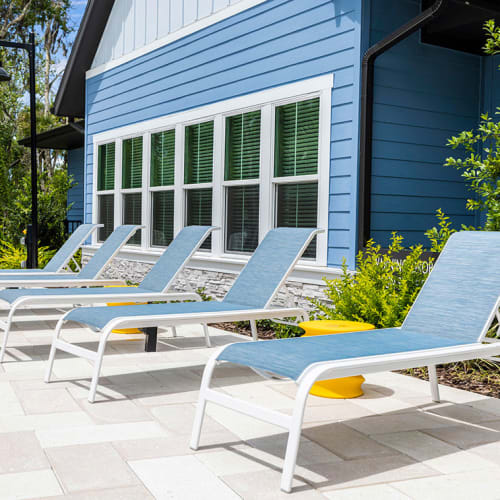 Lounge chairs lined up facing the swimming pool at Integra Trails in Cocoa, Florida