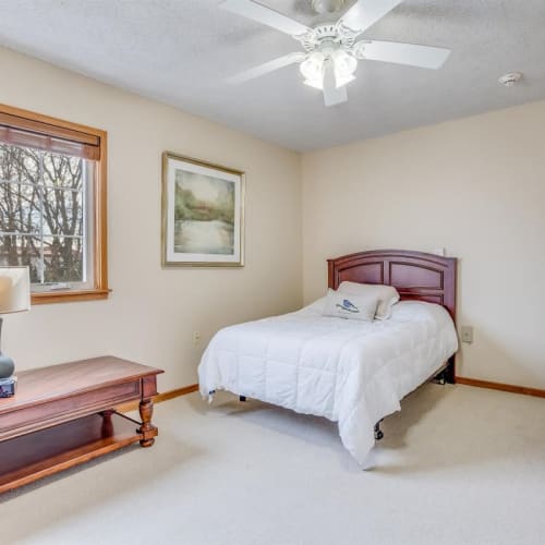 Carpeted bedroom with full-size bed and ceiling fan at Oxford Vista Wichita in Wichita, Kansas