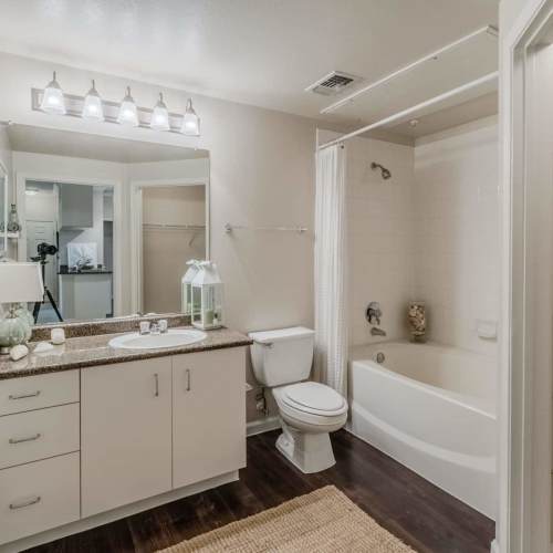 Bright bathroom with white cabinetry and a mirror at Wildwood Creek in Grapevine,Texas