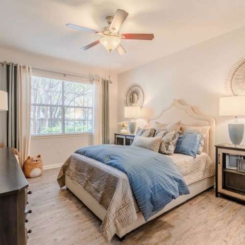 Pleasing bedroom with a large bed, a ceiling fan and storage units at Wildwood Creek in Grapevine,Texas