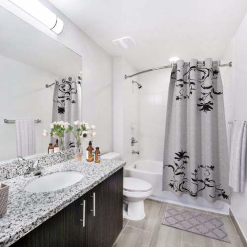 Bathroom with a vanity mirror and a tub at The Olivia in Homestead, Florida
