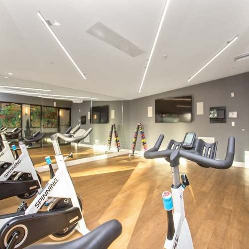 Fitness center with cycles and flat screen televisions at Club Prado in West Miami, Florida