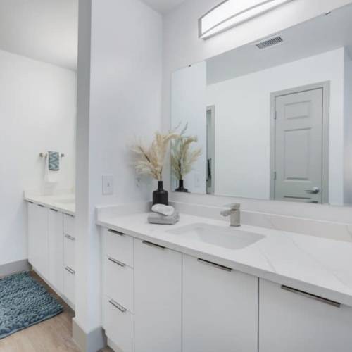 Bright bathroom with a big mirror and storage space at The Kensington in Charlotte, North Carolina
