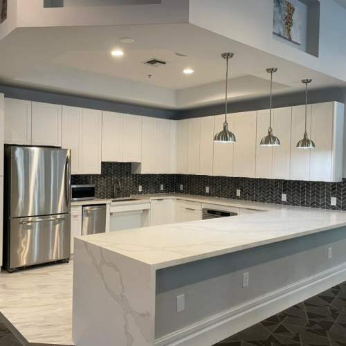 Stainless-steel refrigerator appliances and white cabinets at {location_name}} in Plantation, Florida