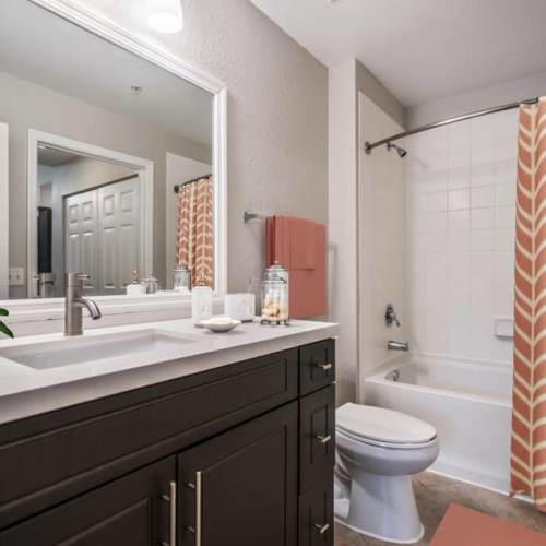 A modern bathroom with a vanity light and a bathtub at Solero at Plantation in Plantation, Florida Solero at Plantation in Plantation, Florida