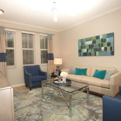 Spacious living room with plush carpeting at {location_name}} in Plantation, Florida