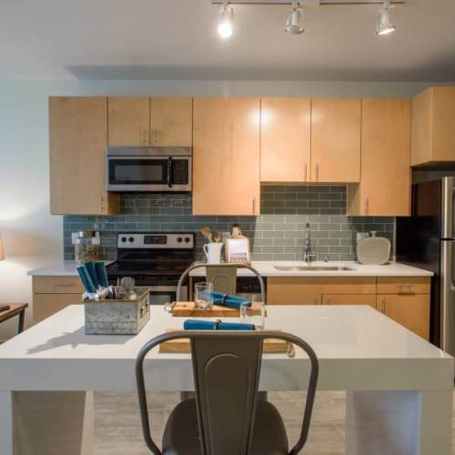 Apartment kitchen with a tile backsplash at LoHi Gold in Denver, Colorado