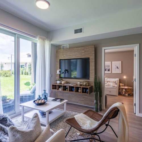 Living room with attached patio and coffee table at Palm Beach Preserve in West Palm Beach, Florida 
