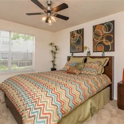 A queen-sized bed in a furnished bedroom at The Granite at Porpoise Bay in Daytona Beach, Florida