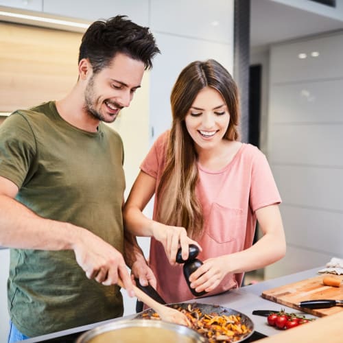 Happy couple cooking at Ellington Apartments in Davis, California