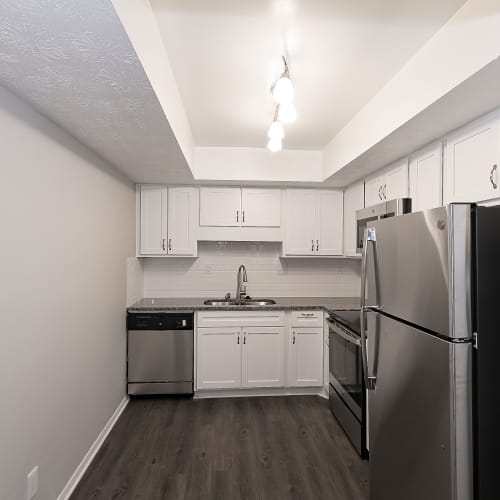 Dark wood flooring and white cabinets in an apartment kitchen at LaVista Crossing in Tucker, Georgia