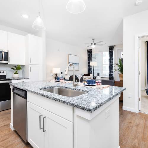 Kitchen island with sink and bar seating in a model home at The Station at San Marco in Jacksonville, Florida