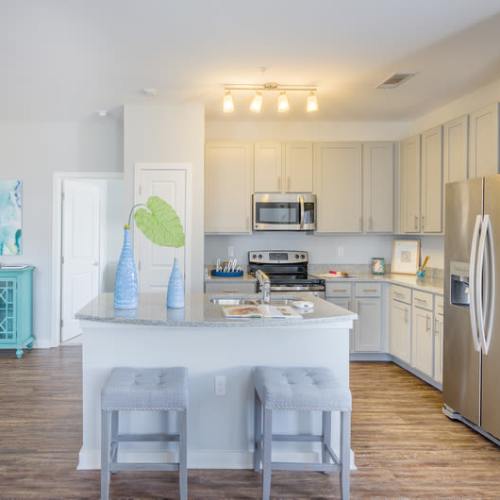 Bar seating at an apartment kitchen's island at Reserve at River Place in Youngsville, Louisiana