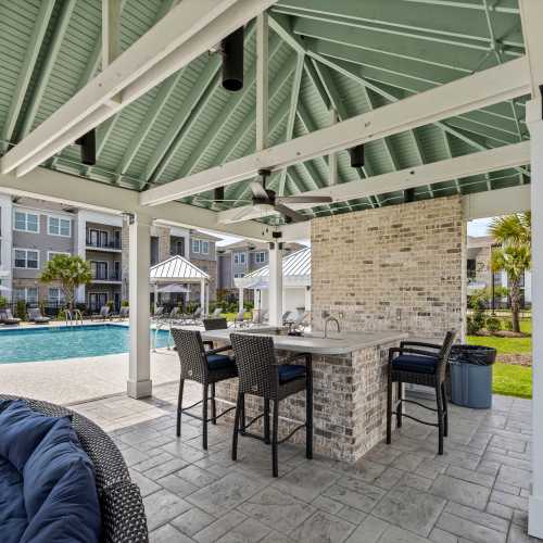 A covered outdoor bar beside the swimming pool at Reserve at River Place in Youngsville, Louisiana